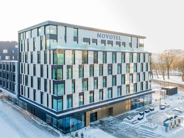 A modern hotel building with a glass facade, labeled 'NOVOTEL,' featuring a symmetrical design and a central entrance. - Novotel Tallinn (Tallinn)