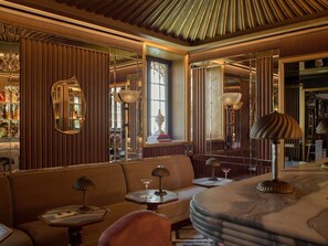 A room with a sofa, a table, and a lamp. There is a mirror on the wall. - Orient Express Venezia (Venice)