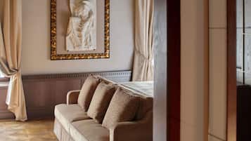 A room with a beige sofa, a framed artwork on the wall, and a window with curtains.