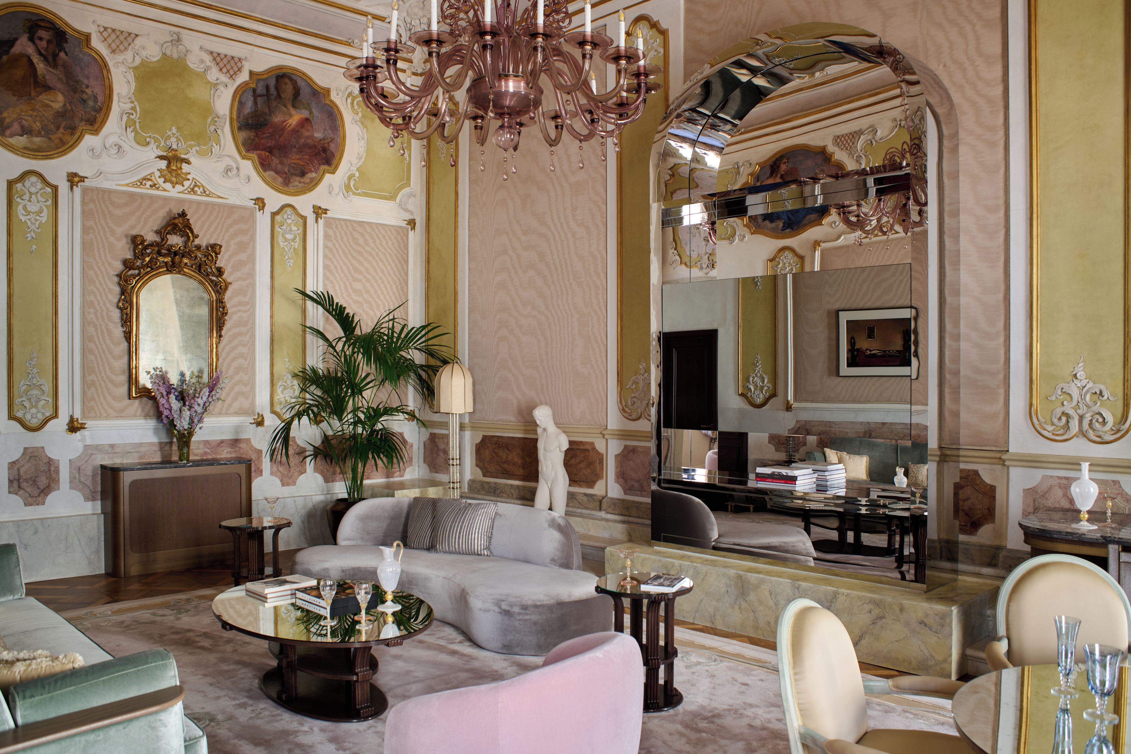Ein luxuriöses Interieur mit einem prächtigen Kronleuchter, aufwendigen Wandverzierungen und einer komfortablen Sitzecke.