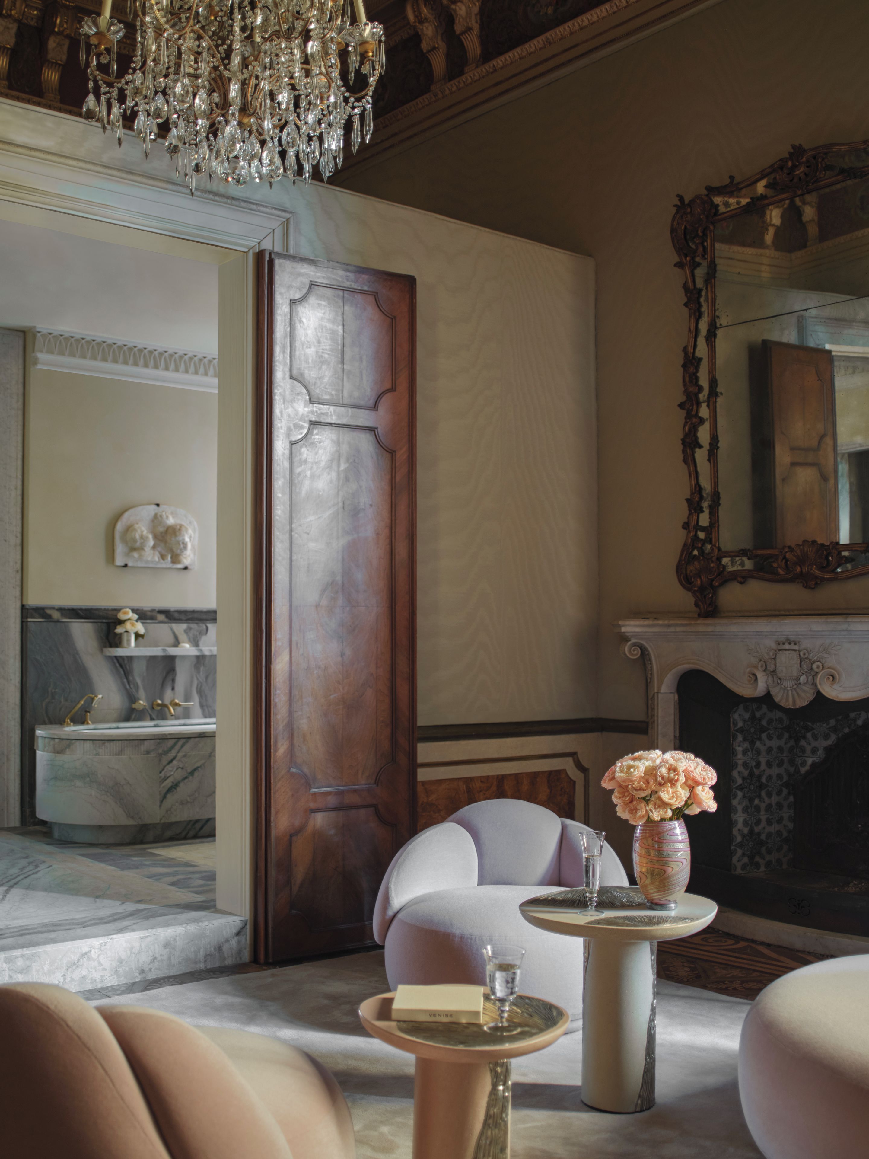 Un intérieur luxueux avec une salle de bain en marbre, un lustre et une cheminée.