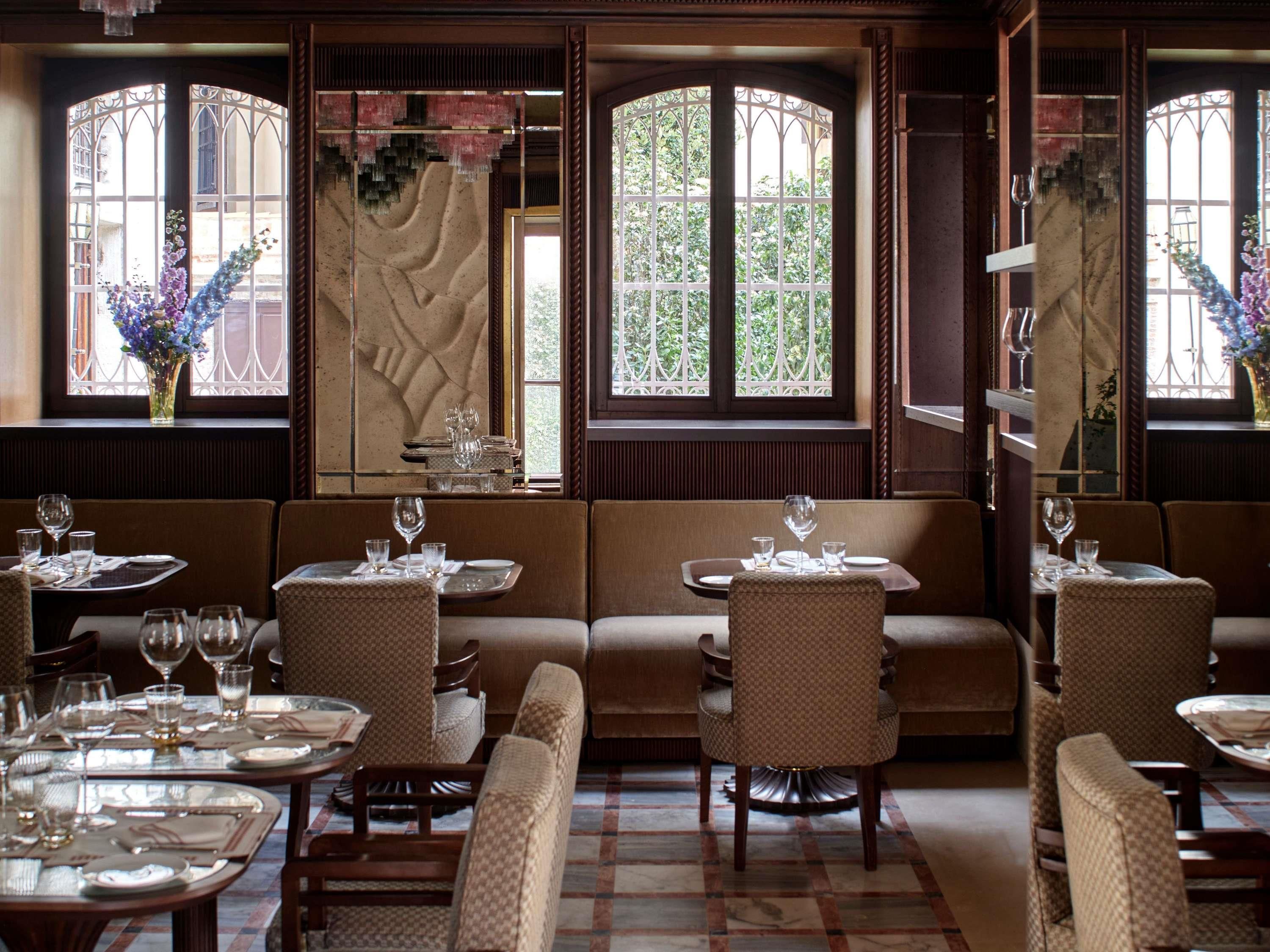 A restaurant interior with booths, round tables, and a patterned floor.