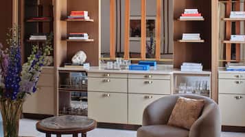 Un interior moderno con una mesa redonda, un sofá y una estantería con libros y objetos decorativos.