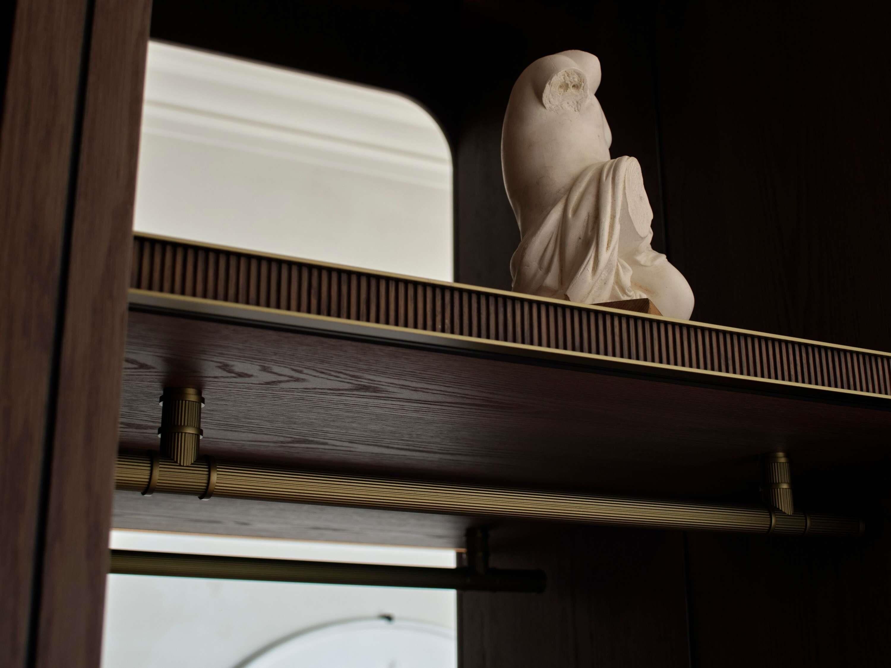 Eine weiße Statue steht auf einem Regal über einer Holzbodenfläche.
