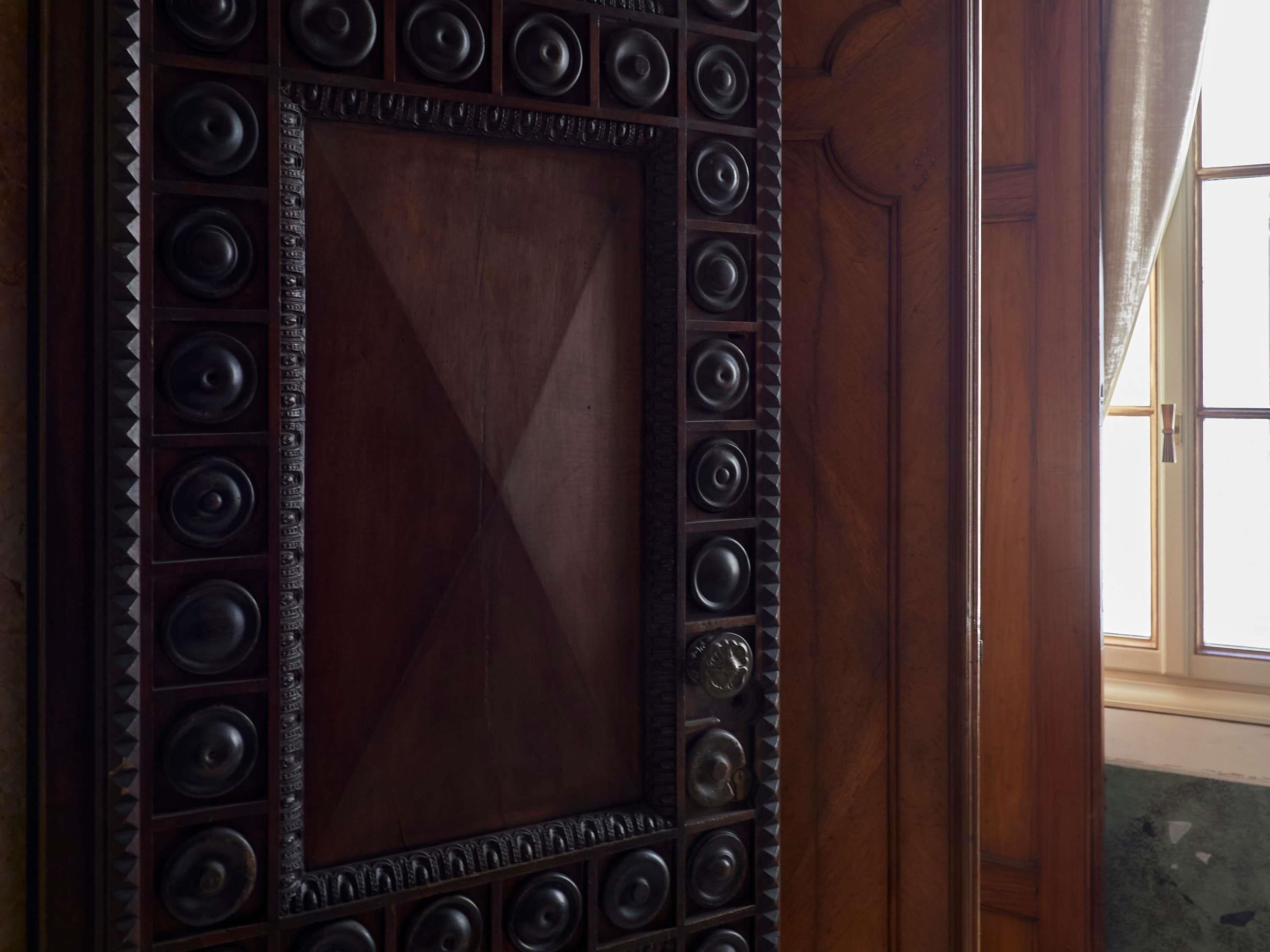 A wooden door with a decorative metal frame and a large central panel.
