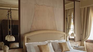 Une chambre d’hôtel avec un grand lit, une table de chevet, un miroir et une fenêtre avec des rideaux.