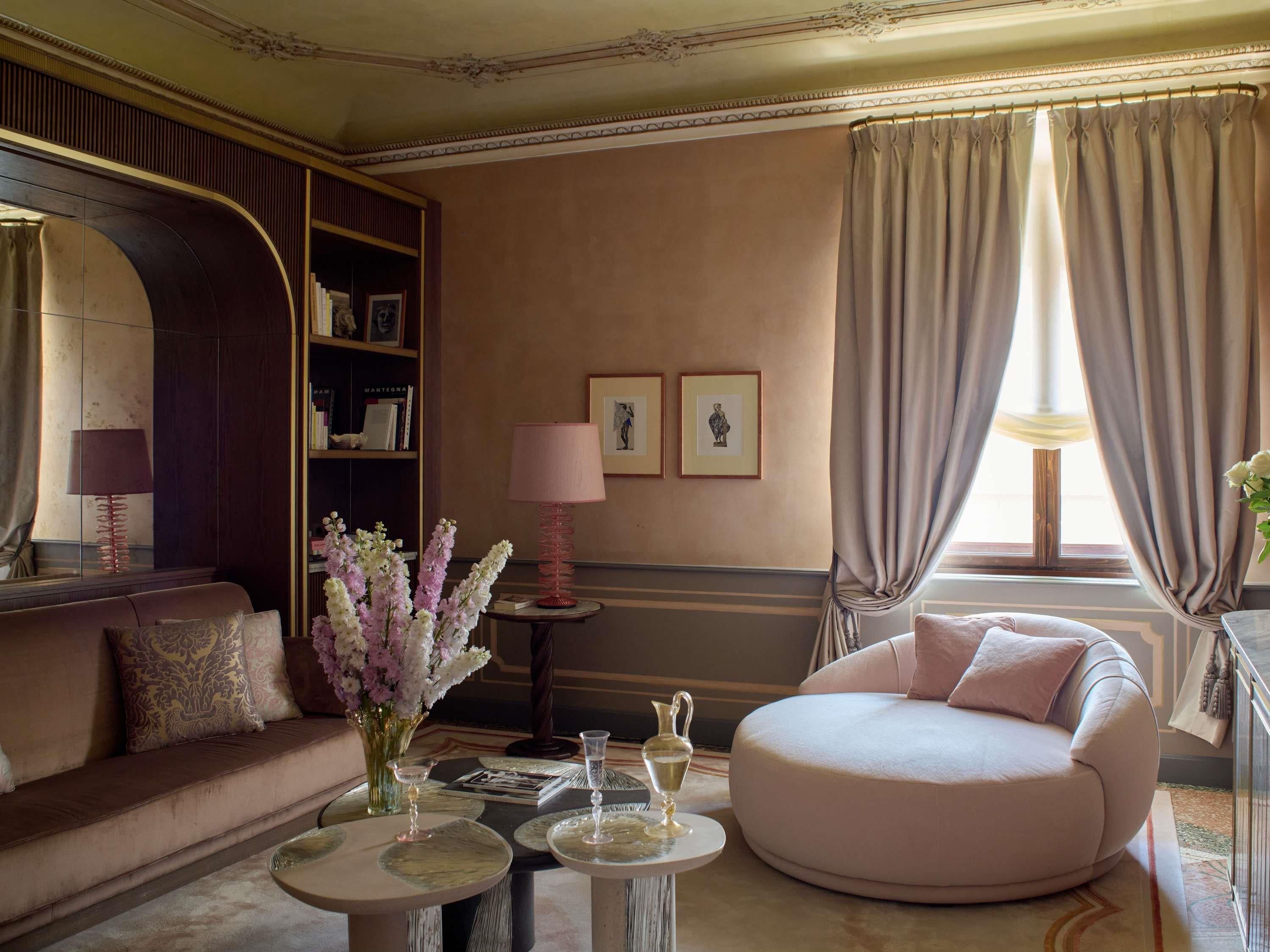 A well-appointed living room with a sofa, a round armchair, a coffee table, and a bookshelf.