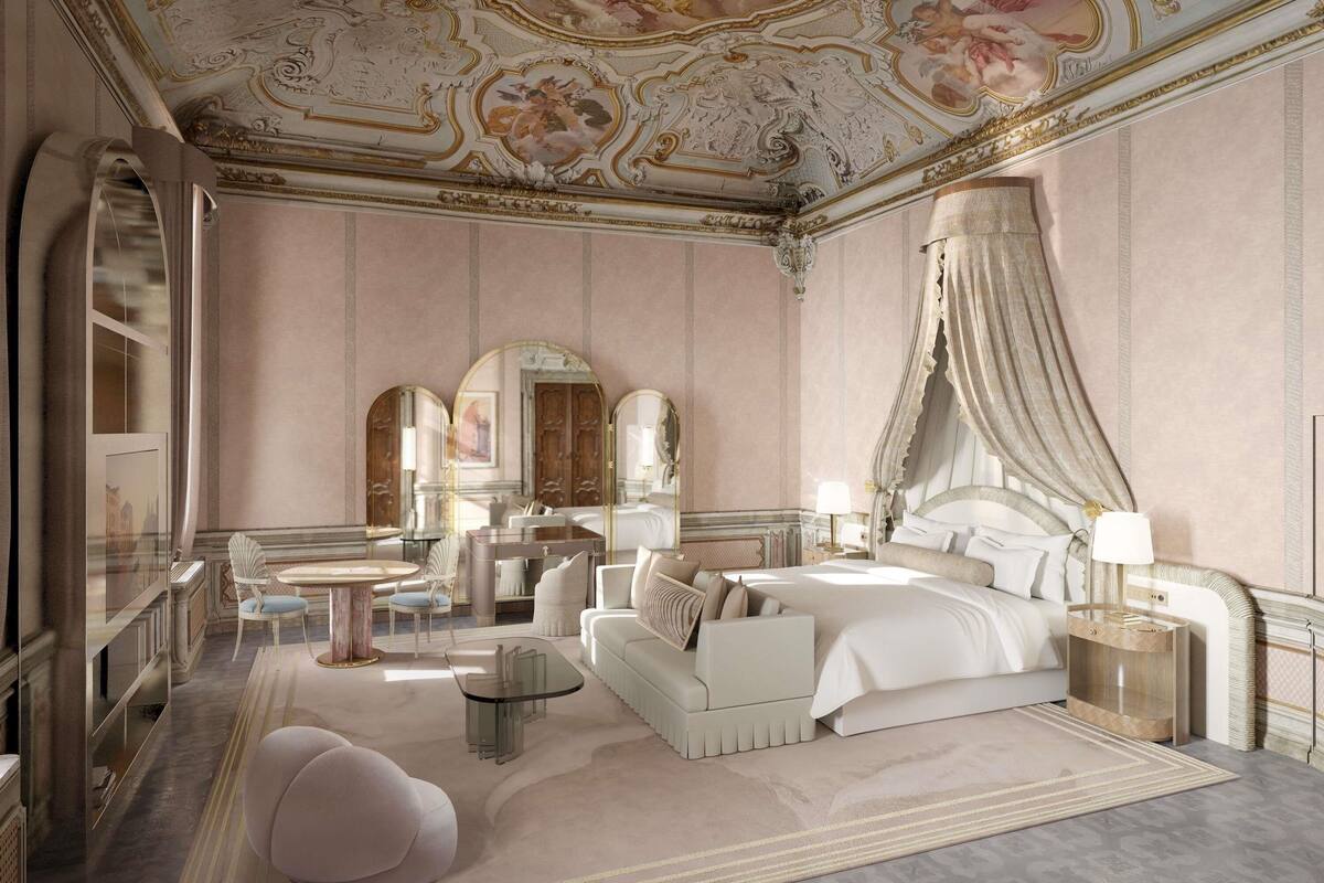 A luxurious bedroom with a canopy bed, a chaise lounge, a glass coffee table, and ornate ceiling artwork.