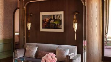 Una habitación con un sofá, una obra de arte enmarcada y un jarrón con flores.