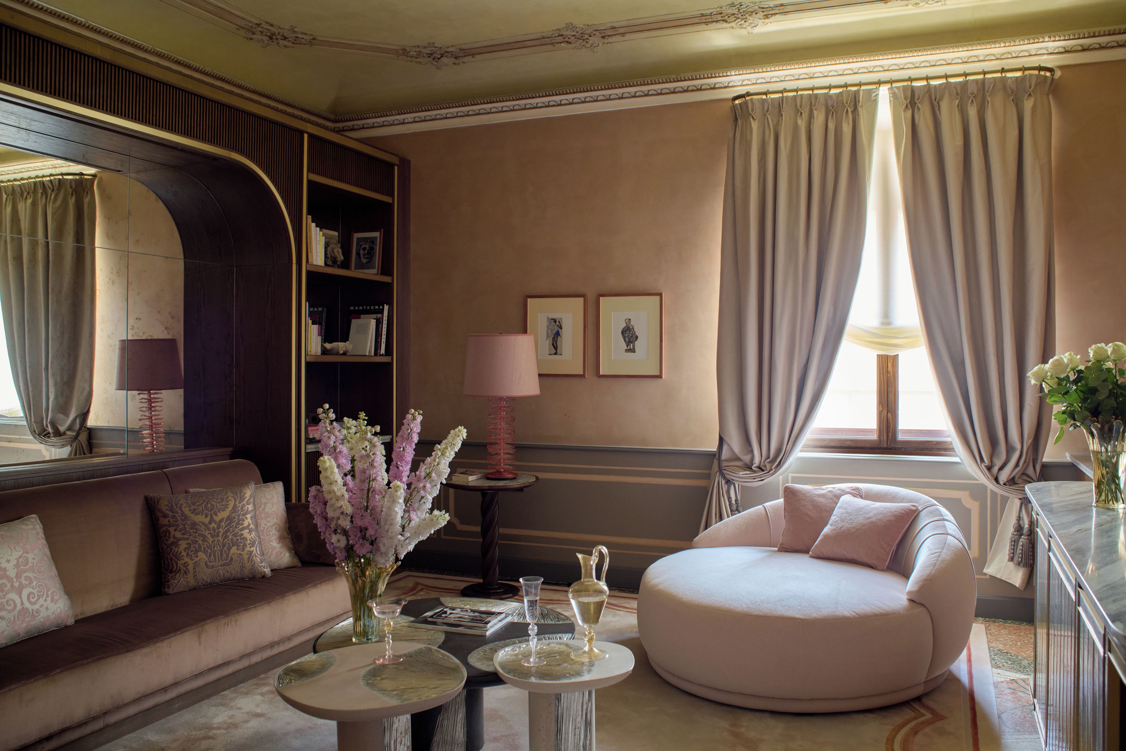A well-appointed living room with a sofa, a round chair, a coffee table, and a bookshelf.