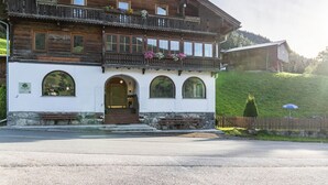 Un bâtiment traditionnel en bois, doté de balcons, de fenêtres en arc de cercle et d’une fondation en pierre.