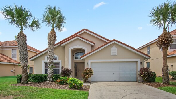 A residential house with a beige facade, a red-tiled roof, and a white garage door. There are palm trees and a well-maintained lawn in front. - 5BR,3BA Villa in Solana Resort,Pool,Near Disney (Davenport)