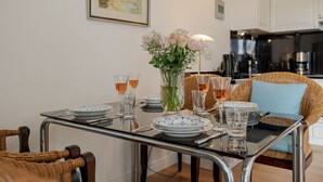 En matplats med ett glasbord för två personer, omgiven av stolar i rotting.