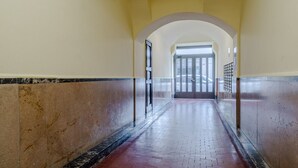 Un corridoio con pareti piastrellate, una cornice in marmo e un pavimento in mattoni.