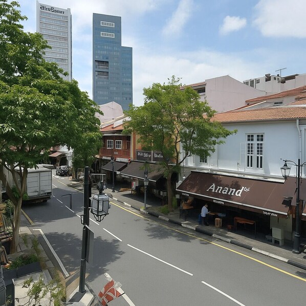 A street view with a building labeled "Anand" and a modern high-rise in the background.