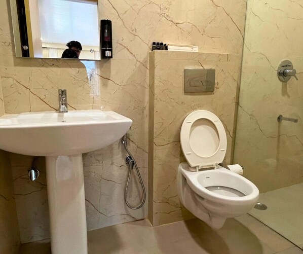 Un baño con lavamanos, inodoro y ducha.
