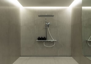 A modern shower with a handheld showerhead and a wall-mounted faucet. - UniIsland The SpaVille (Incheon)