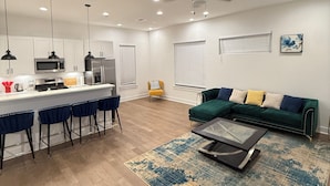 Un espace de vie moderne comprenant une cuisine, un coin repas et un espace détente.