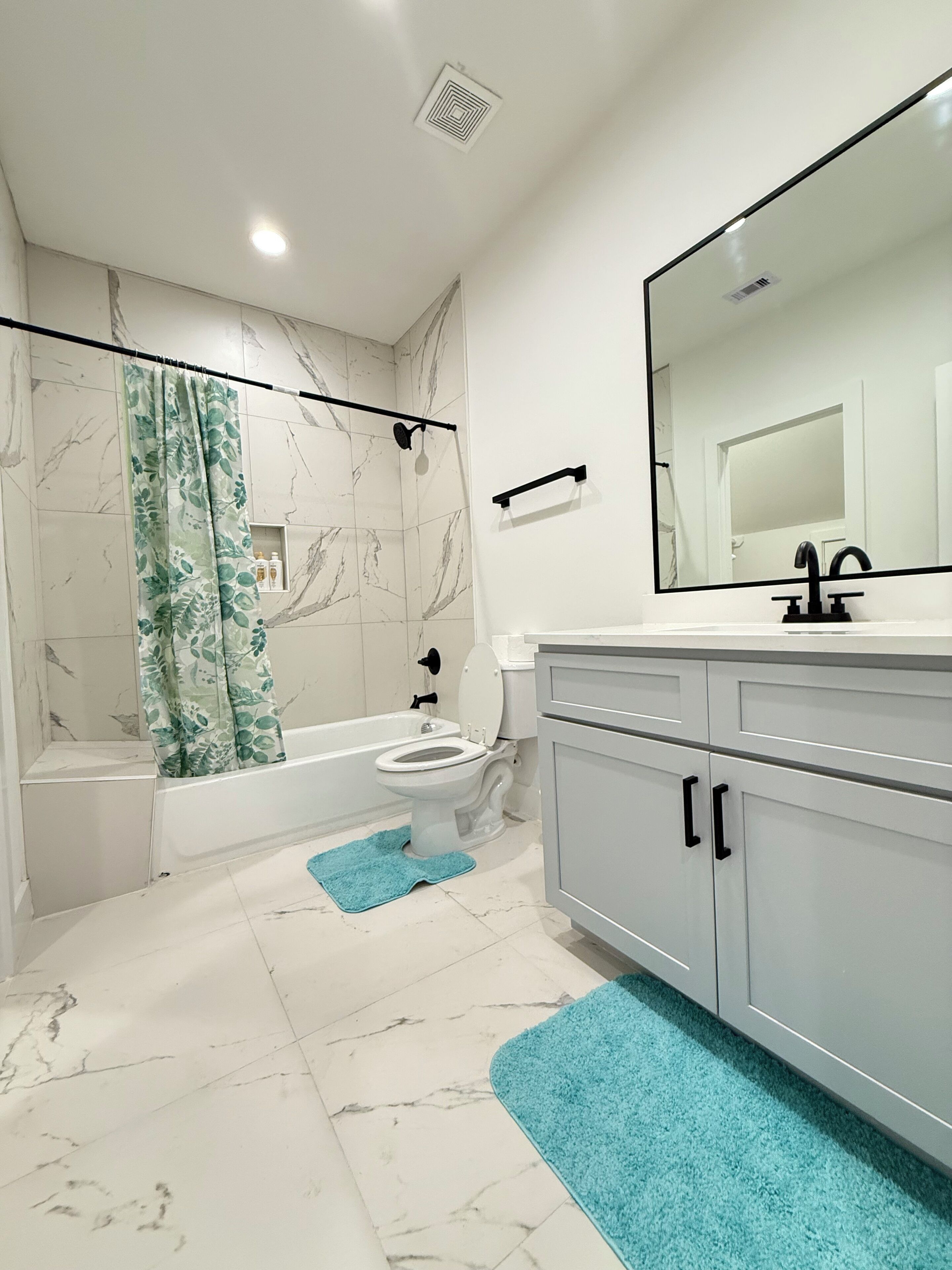 A modern bathroom with a bathtub, toilet, and sink.