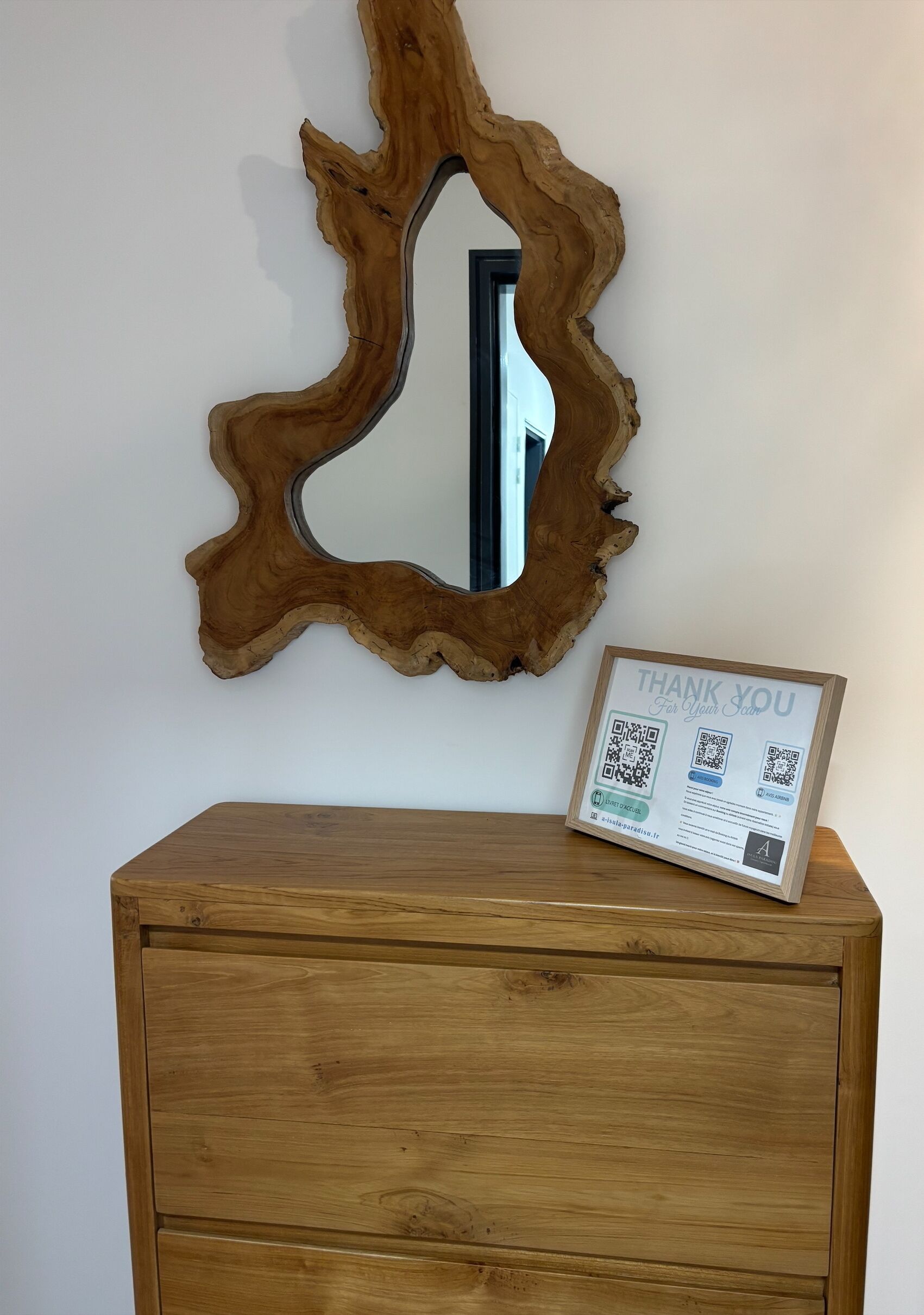 Een houten kast met een spiegel en een bedankkaartje.
