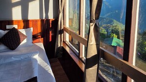 Un dormitorio con un ventanal que ofrece vistas a la montaña.