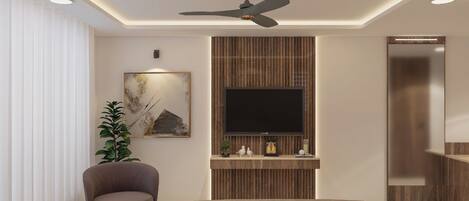 Un dormitorio moderno con una televisión de pantalla plana montada en una pared de paneles de madera, un ventilador de techo, una planta grande en maceta y una zona de estar con sofá y sillón.