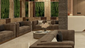 Una sala de estar moderna con varios sofás y una mesa de centro, con un jardín vertical verde y una pared de piedra texturizada.