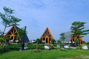 Three triangular-roofed buildings with a central entrance, surrounded by well-maintained gardens and outdoor seating areas.