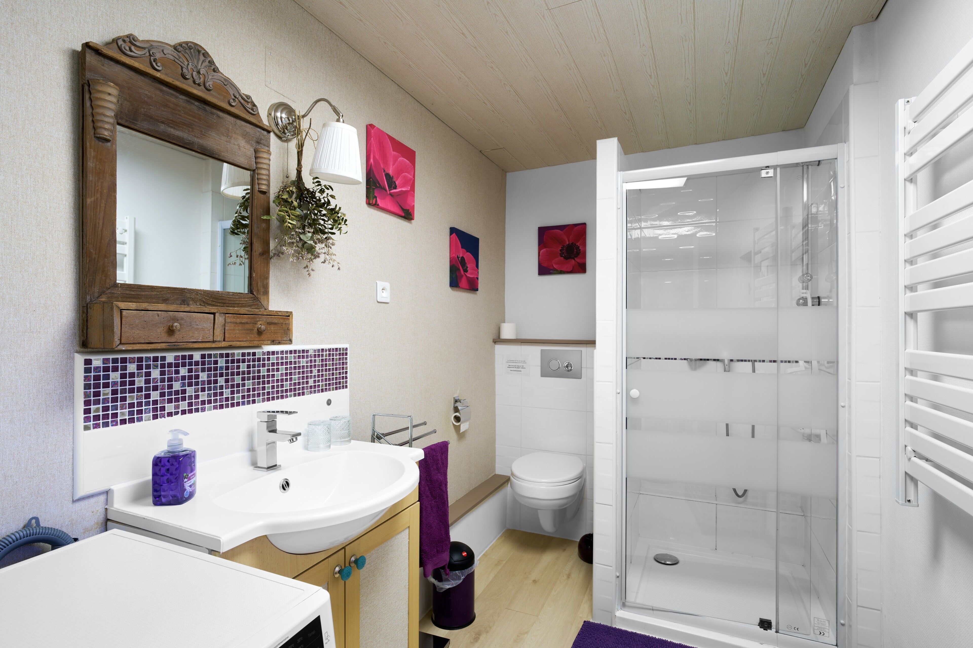 Un baño con lavamanos, espejo, inodoro y ducha.