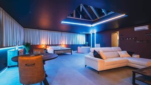 Ein modernes Wohnzimmer mit einer Couch, einem Esstisch und einem Bett.