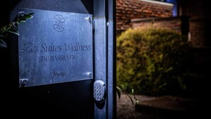 Eine Metallplakette mit der Aufschrift 'Les Suites Wellness DE BASSENGE Soma' ist an einer Tür mit einem Zahlenschloss befestigt.