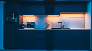 A modern kitchen with a marble countertop, a built-in oven, and a sleek faucet.