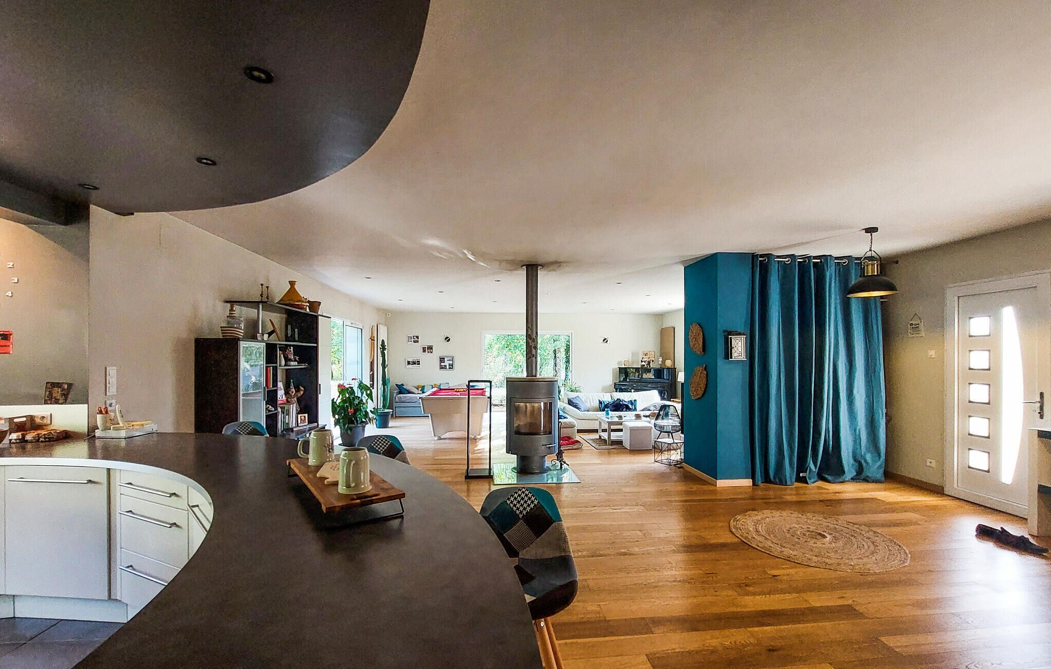 A spacious living area with a kitchen, dining table, and a large window.