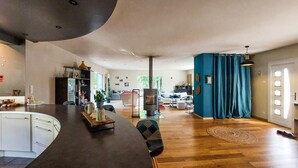 A spacious living area with a kitchen, dining table, and a large window. - 3 bedroom nice home in Sarliac (Sarliac)