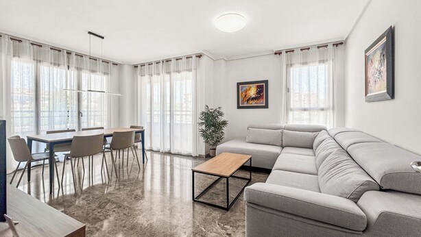 A modern living room with a sofa, dining table, chairs, and a coffee table. - NEW! Ciudad de las Artes Apartment (València)