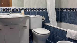 A bathroom with a sink, toilet, bathtub, and a shower curtain. - NEW! Ciudad de las Artes Apartment (València)