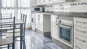 A modern kitchen with white cabinets, a built-in oven, microwave, and washing machine. - NEW! Ciudad de las Artes Apartment (València)