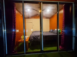 Um quarto com uma cama, uma mesinha de cabeceira e um ventilador de teto.