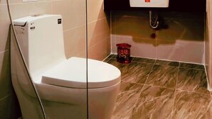 Ein modernes Badezimmer mit Toilette, Waschbecken und Duschbereich.