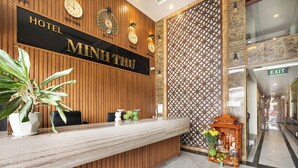 Ein Hotelrezeptionstresen mit Holzpaneelen, einer Uhr und einem Schild mit der Aufschrift 'HOTEL MINH THU'.