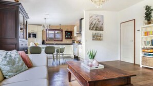A modern living room with a wooden coffee table, a sofa, and a dining area with chairs. - Amazing home in Erm with WiFi (Erm)