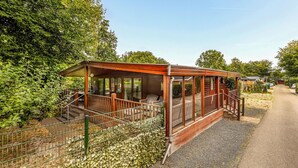 A wooden cabin with a porch, a staircase, and a fenced garden area. - Amazing home in Erm with WiFi (Erm)