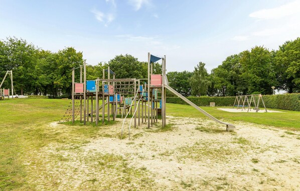 A playground with climbing structures, slides, and swings.