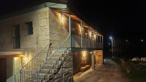 Ein Steinhaus mit einer Treppe, die zu einem Balkon führt.