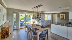 Una cocina moderna con comedor, ventanas amplias y vista al patio trasero.