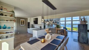 Cocina amplia con una isla central, elegantes lámparas colgantes y vistas al mar a través de grandes ventanales.