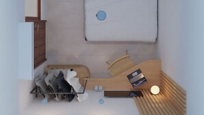 A compact room with a bed, a small desk, and a shelf with shoes and a book. - Samara Stay by Sinergi (Semarang)
