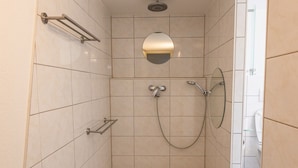 A modern shower with a handheld showerhead, a wall-mounted faucet, and a tiled floor. - Apartment 'Alexandra' with Shared Terrace, Shared Garden and Wi-Fi (Aldingen)