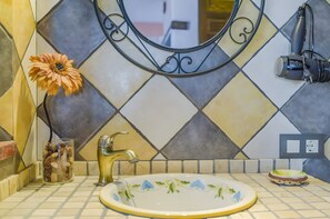 A bathroom with a sink, mirror, and decorative tiles. - Apartment 'Castaño' with Shared Pool, Wi-Fi and Air Conditioning (Barbate)