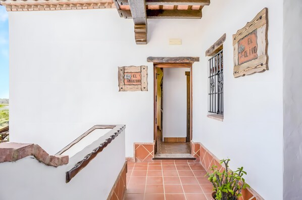 A staircase leading to a door with rustic wall decorations and a potted plant.